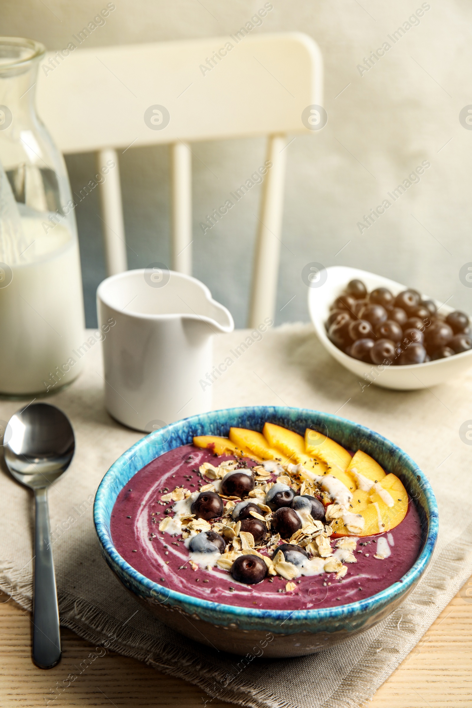 Photo of Bowl with tasty acai smoothie on wooden table