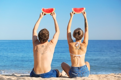 Photo of Young couple with watermelon slices on beach