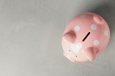 Ceramic piggy bank on light grey table, top view. Space for text