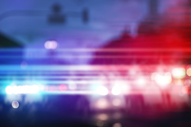Image of Blurred view of police cars on street at night