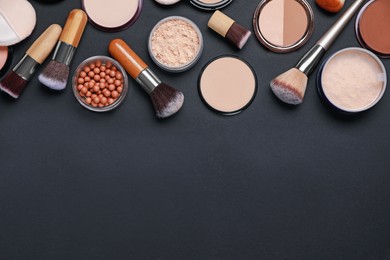 Photo of Different face powders and makeup brushes on black background, flat lay. Space for text