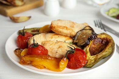 Photo of Tasty cooked chicken fillet and vegetables served on white wooden table, closeup. Healthy meals from air fryer