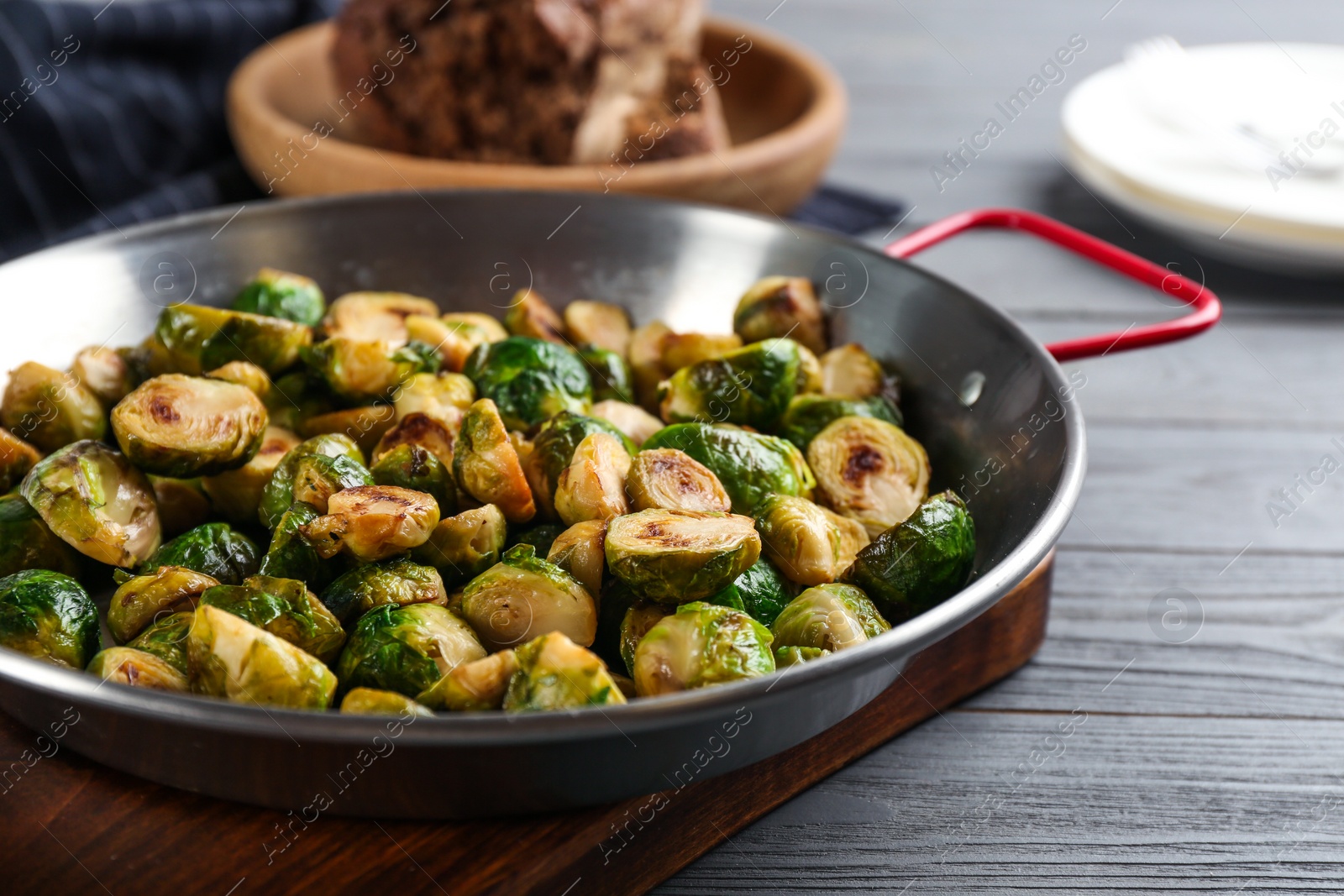 Photo of Delicious roasted brussels sprouts on grey wooden table, closeup