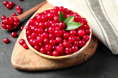 Photo of Tasty ripe cranberries on black table, closeup