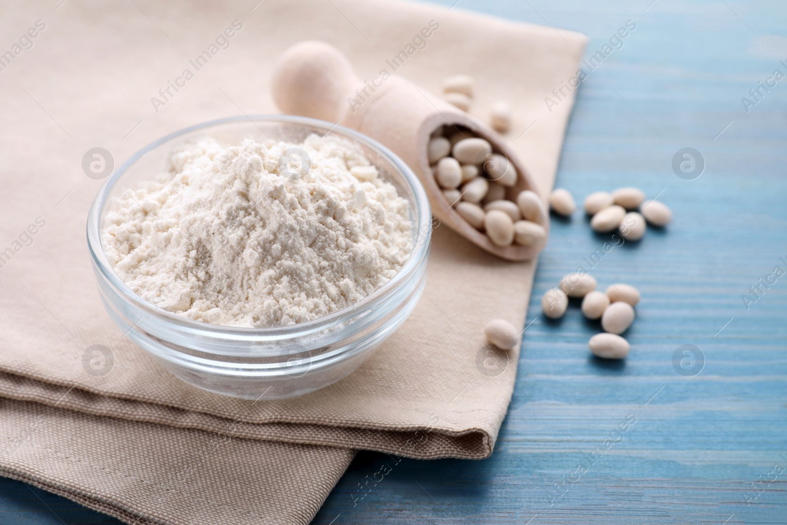 Kidney bean flour and seeds on light blue wooden table, closeup Photo of Kidney bean flour and seeds on light blue wooden table, closeup