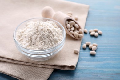 Photo of Kidney bean flour and seeds on light blue wooden table, closeup