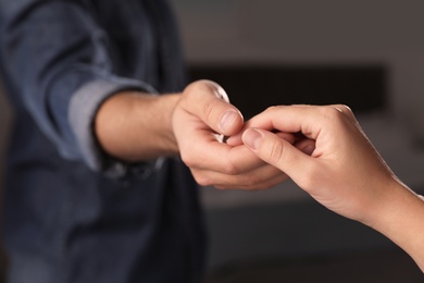 Photo of Man giving helping hand to woman indoors, closeup