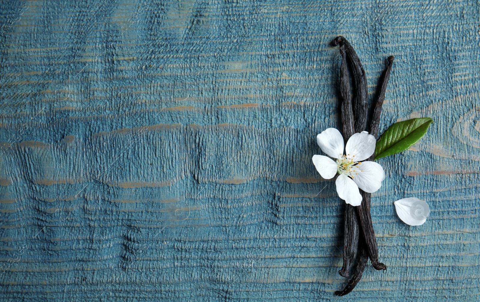 Photo of Flat lay composition with aromatic vanilla sticks and flower on wooden background, space for text