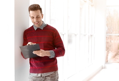 Photo of Male real estate agent with clipboard indoors