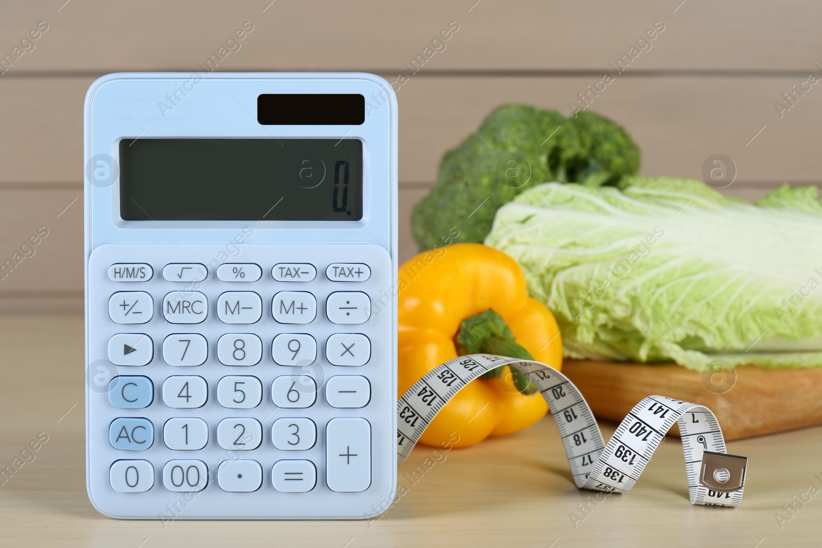 Photo of Calculator and food products on wooden table. Weight loss concept