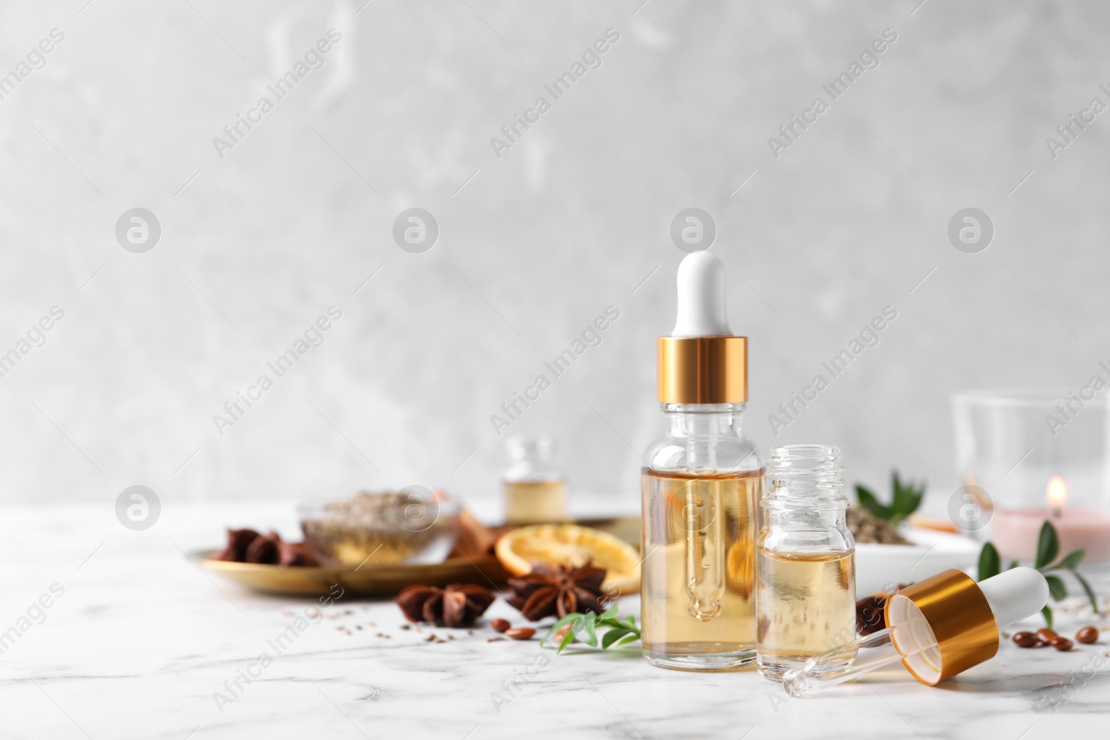 Photo of Anise essential oil and spice on white table, space for text