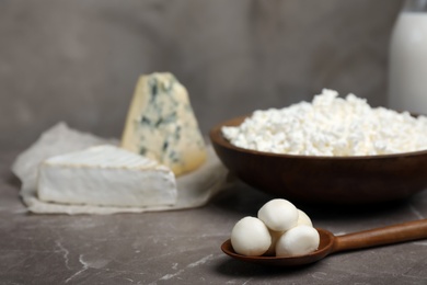 Spoon with fresh mozzarella balls on table. Dairy products