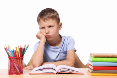 Photo of Little boy with stationery and books suffering from dyslexia at wooden table