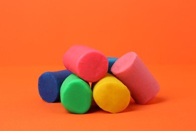 Photo of Different bright play dough on orange background