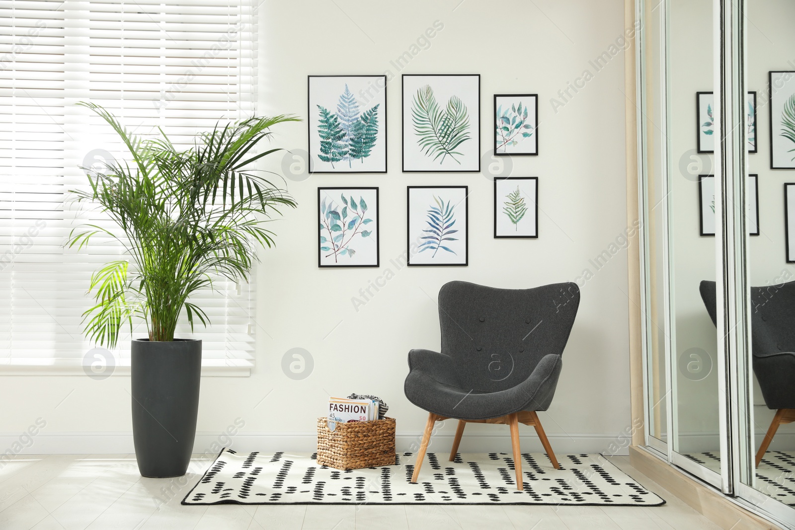 Photo of Beautiful paintings of tropical leaves on white wall in room interior