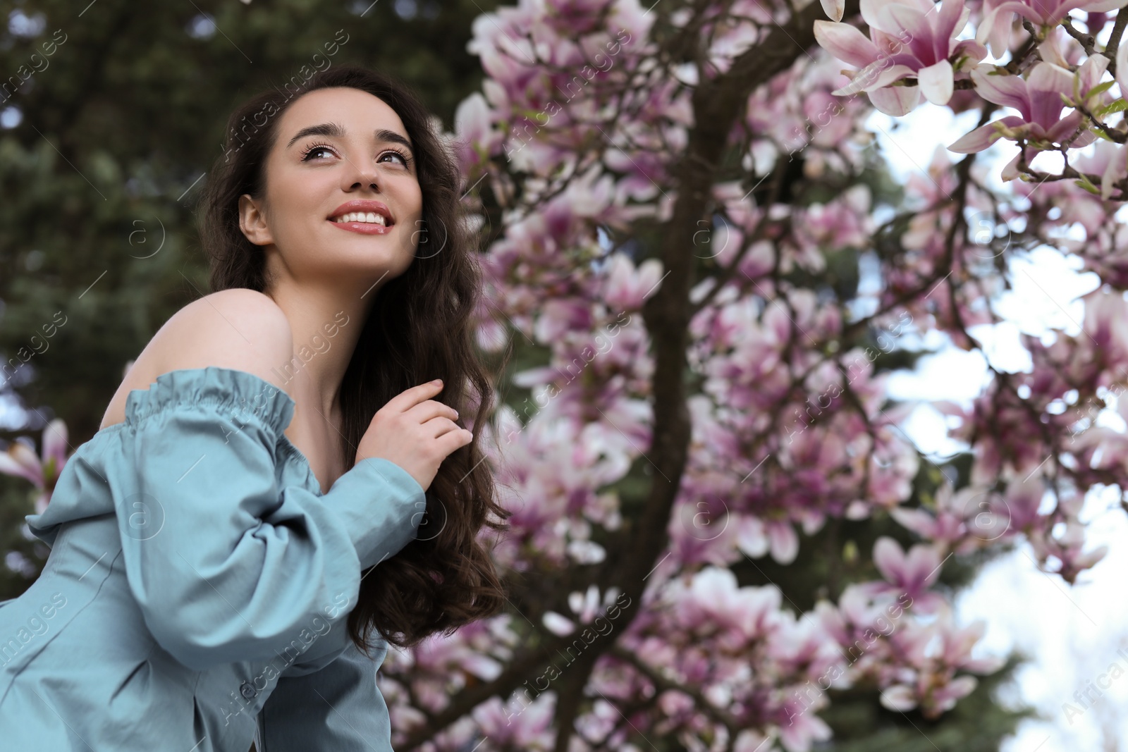 Photo of Beautiful woman near blossoming magnolia tree on spring day