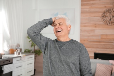 Photo of Portrait of mature man laughing at home