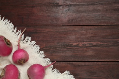 Photo of Red turnips on wooden table, flat lay. Space for text