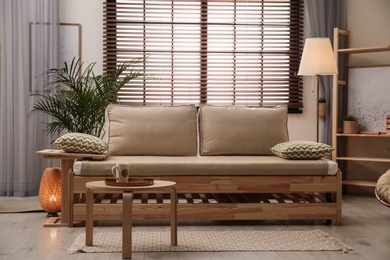 Living room interior with sofa, window blinds and stylish decor elements