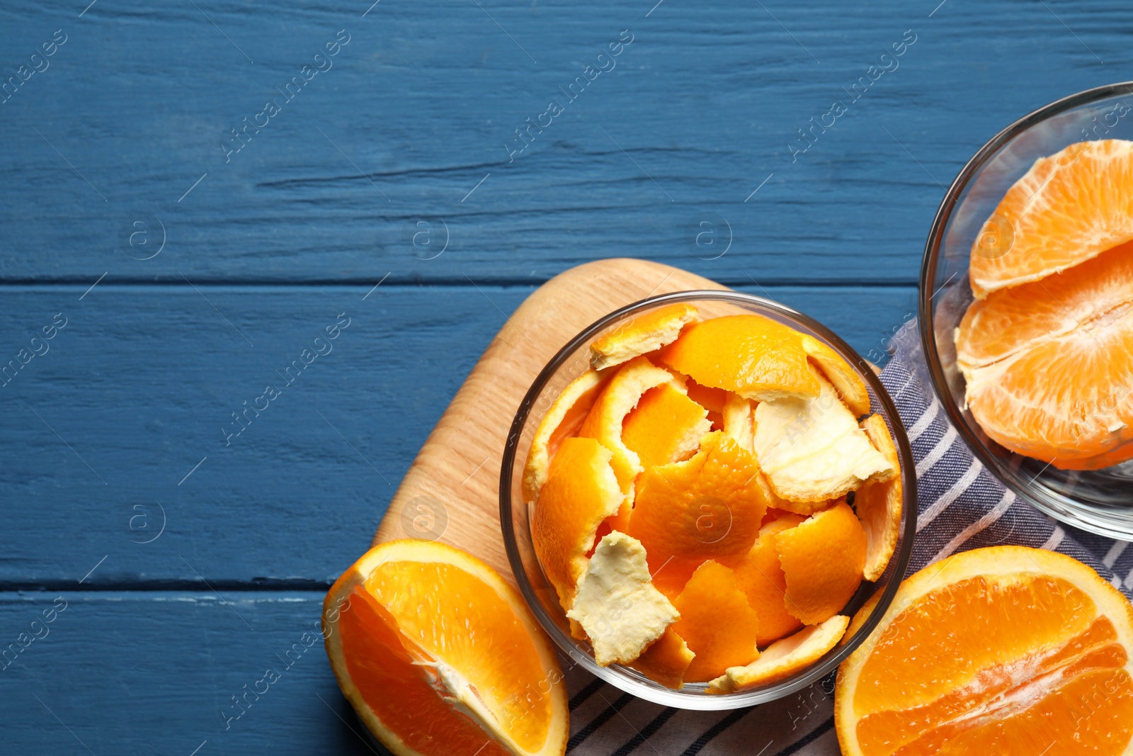 Photo of Orange peels preparing for drying and fresh fruits on blue wooden table, flat lay. Space for text