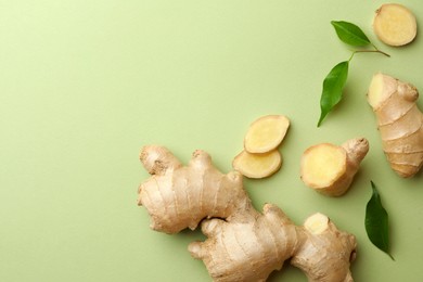 Photo of Fresh ginger with leaves on light pale green background, flat lay. Space for text