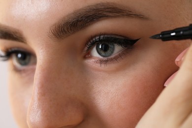 Photo of Makeup product. Woman applying black eyeliner, closeup