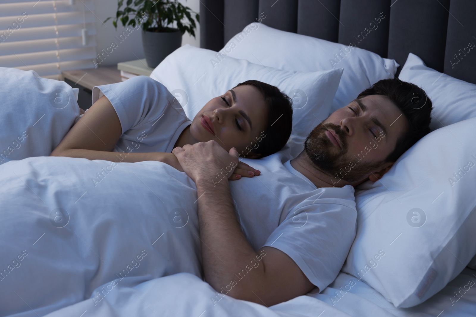 Photo of Lovely couple sleeping together in bed at night