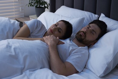 Photo of Lovely couple sleeping together in bed at night