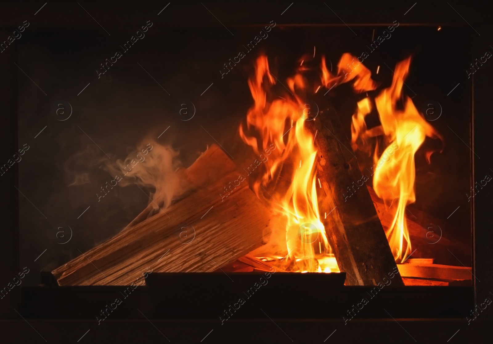 Photo of Fireplace with burning wood, closeup view. Winter vacation