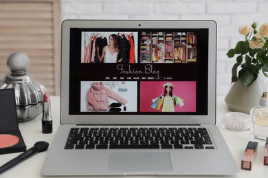 Photo of Laptop with open fashion blogger site on table