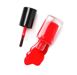 Spilled color nail polish with bottle and brush on white background, top view