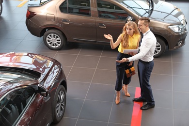 Young car salesman working with client in dealership