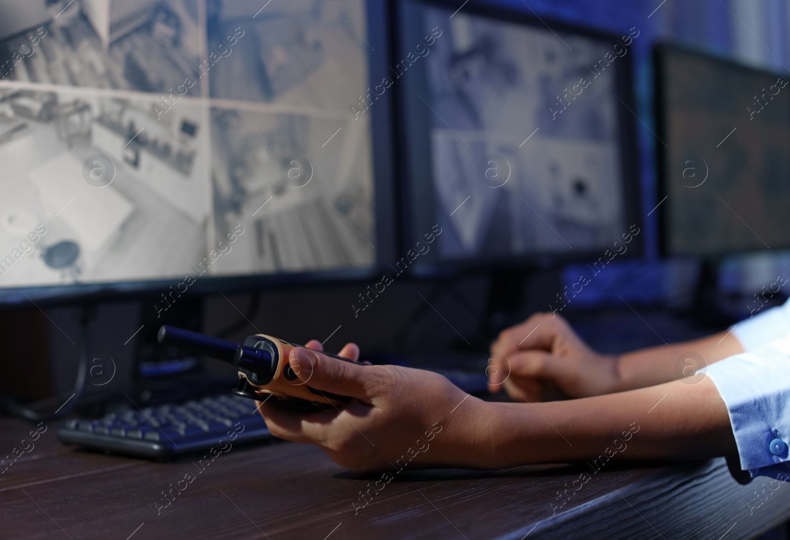 Photo of Female security guard with portable transmitter monitoring modern CCTV cameras indoors, closeup