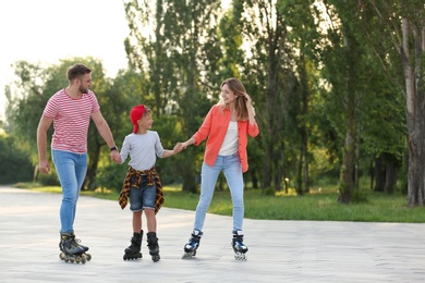 Photo of Happy family roller skating on city street. Space for text
