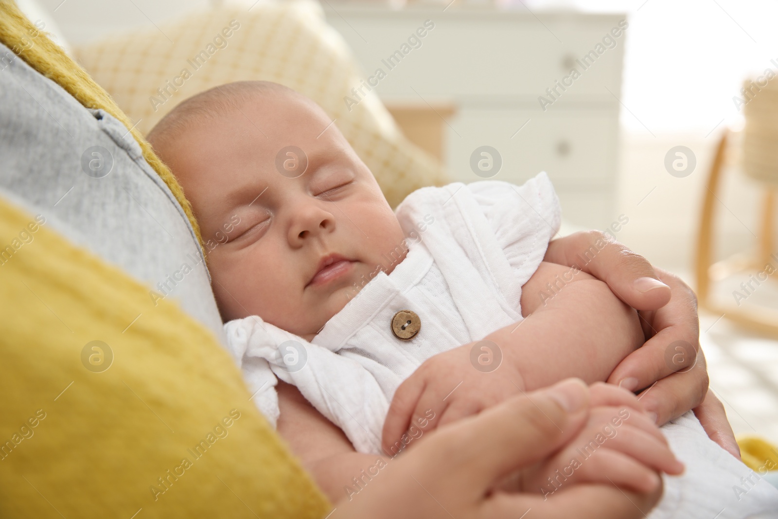 Photo of Mother holding her sleeping baby at home, closeup