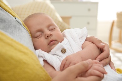 Photo of Mother holding her sleeping baby at home, closeup