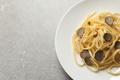 Tasty fettuccine with truffle on grey table, top view. Space for text