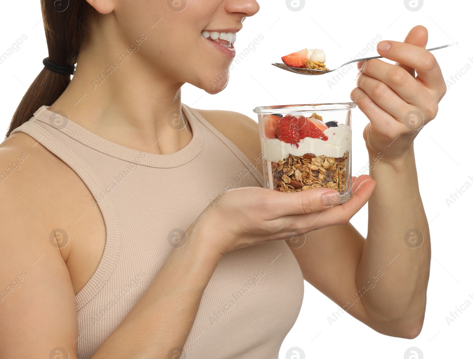 Photo of Happy woman eating tasty granola with fresh berries and yogurt on white background, closeup