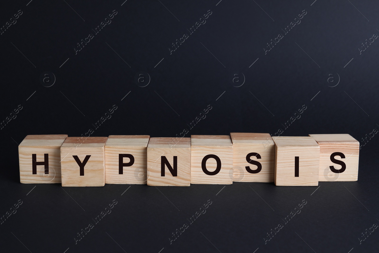 Photo of Wooden blocks with word HYPNOSIS on black background