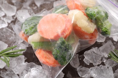 Photo of Mix of different frozen vegetables with ice on table, closeup