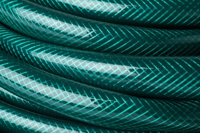 Green rubber watering hose as background, closeup