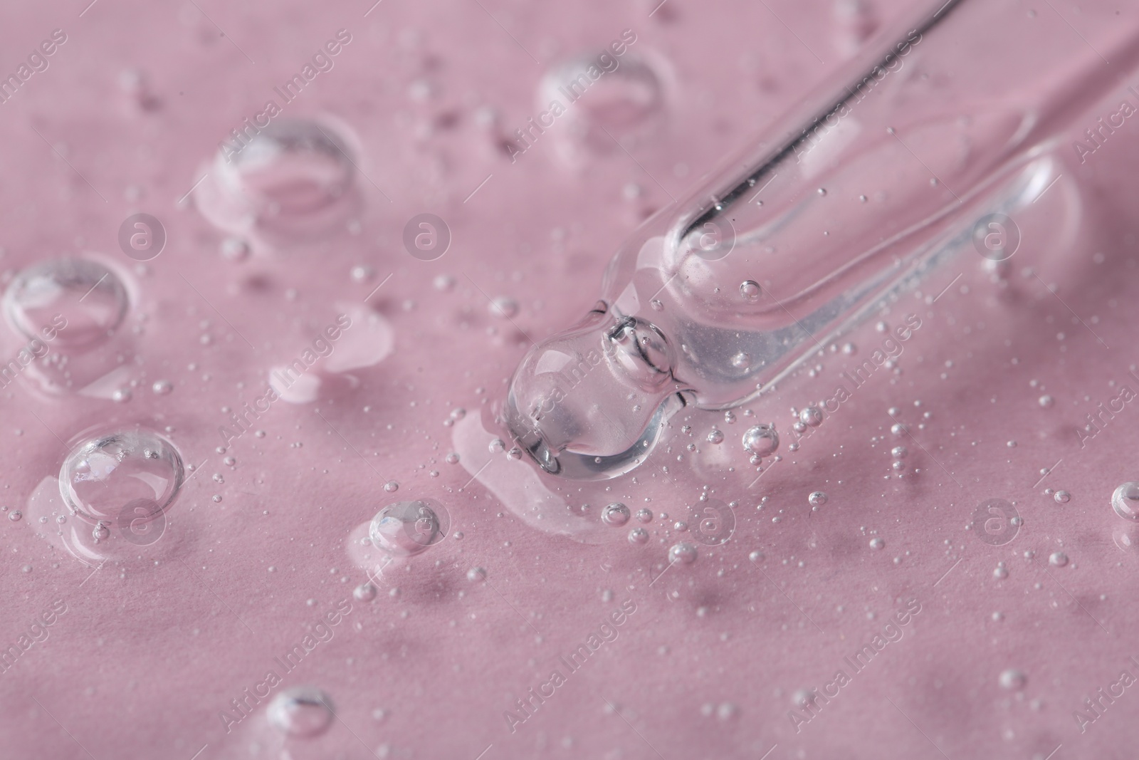 Photo of Pipette with cosmetic serum on pink background, closeup