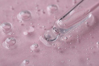 Photo of Pipette with cosmetic serum on pink background, closeup