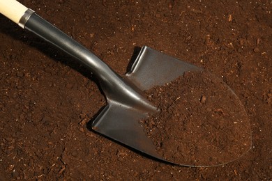 Photo of Metal shovel on fertile soil. Gardening tool