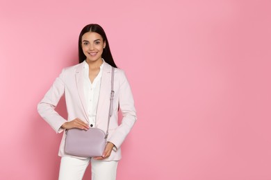 Photo of Beautiful young woman with stylish bag on pink background, space for text