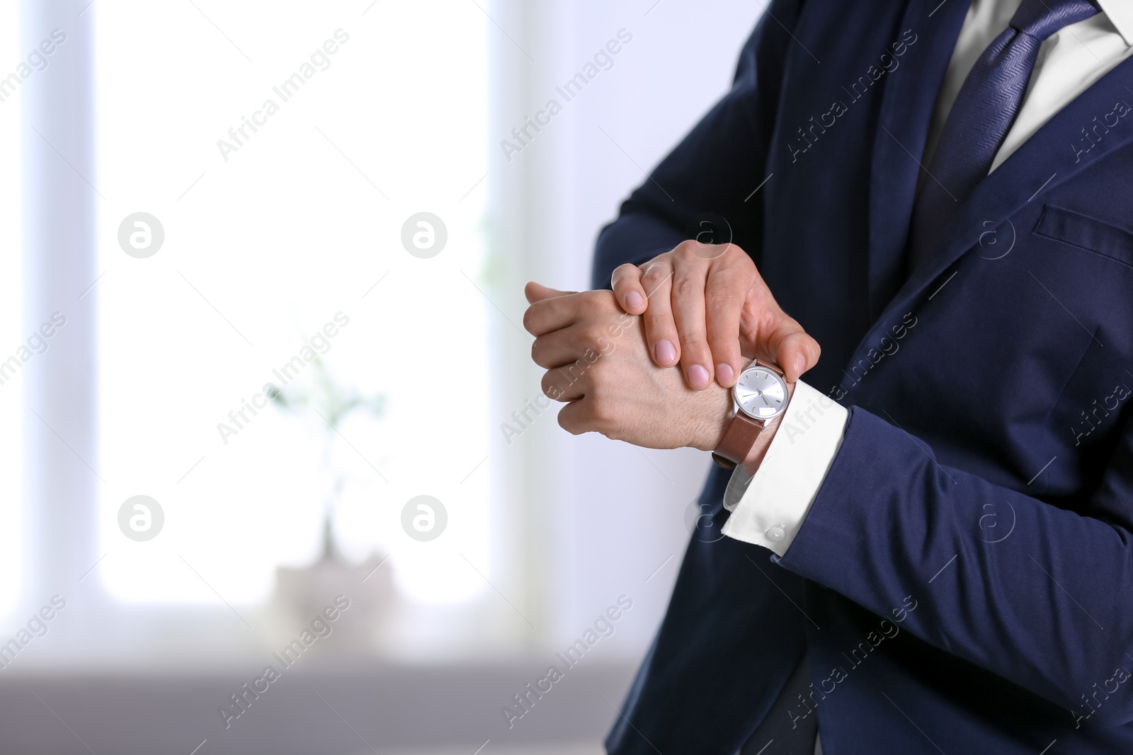 Photo of Businessman with wristwatch on blurred background, Time concept