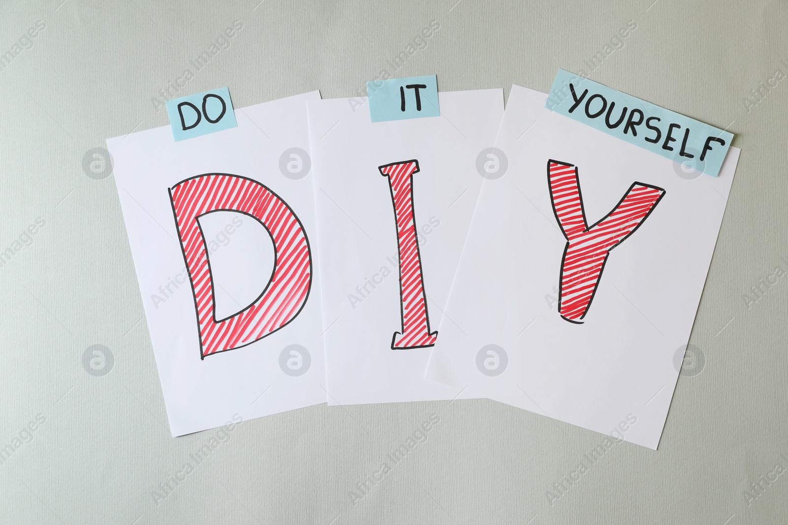 Photo of Phrase Do It Yourself and abbreviation DIY made of letters on light grey background, flat lay