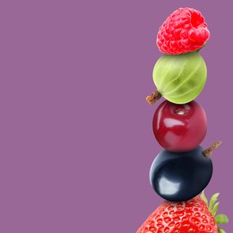 Stack of different fresh tasty berries and cherry on pale purple background, space for text