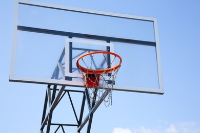 Photo of Basketball backboard with hoop outdoors against blue sky