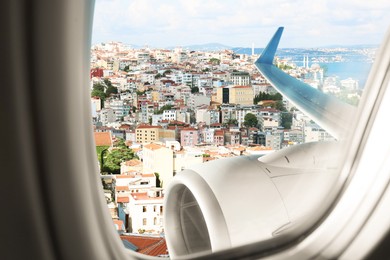 Image of Beautiful city with buildings, view through airplane window during flight